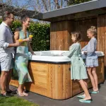 Famille s’essuyant après un bain nordique Nordic Hottub Spa avec finition en cèdre rouge dans le jardin