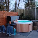 Femme profitant d’un bain nordique Nordic Hottub Classic nouvellement installé avec finition en cèdre rouge et cuve intérieure en plastique HDPE