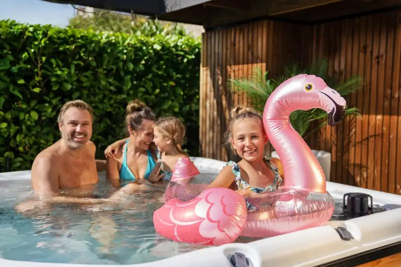 Famille heureuse dans un bain nordique Nordic Hottub Spa avec finition en cèdre rouge