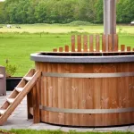 Vue latérale du bain nordique Ticra en Thermowood avec poêle interne et revêtement en bois