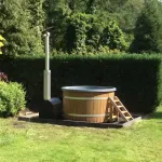 Mooie hottub buiten in de zon met externe houtkachel in de tuin