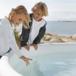 Enfants jouant près du bain nordique sécurisé Skargards Rojal avec poêle intégré