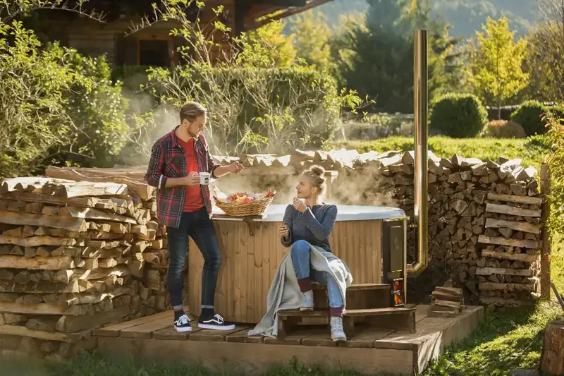 Couple profitant d'un petit-déjeuner à côté du bain nordique Skargards Rojal chauffé au bois