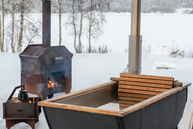Baignoire extérieure Hikki Bohemen chauffée au bois dans un paysage enneigé
