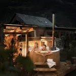 Stel geniet in het avondlicht van de stomende Skargards Panel hottub met interne kachel