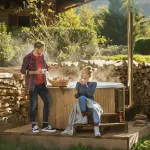 Couple profitant d'un petit-déjeuner à côté du bain nordique Skargards Rojal chauffé au bois