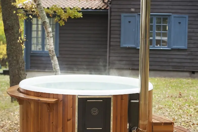 Bain nordique Skargards Rojal chauffé avec poêle intégré dans un jardin privé