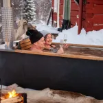 Vue latérale d'un couple profitant du bain nordique Hikki Bohemen dans la neige