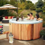 Famille se détend ensemble dans un bain nordique Ticra Classic dans le jardin.