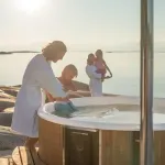 Famille heureuse profitant du bain nordique Skargards Rojal avec poêle intégré