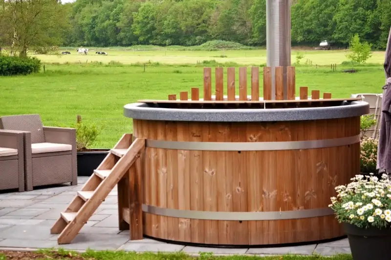 Vue latérale du bain nordique Ticra en Thermowood avec poêle interne et revêtement en bois
