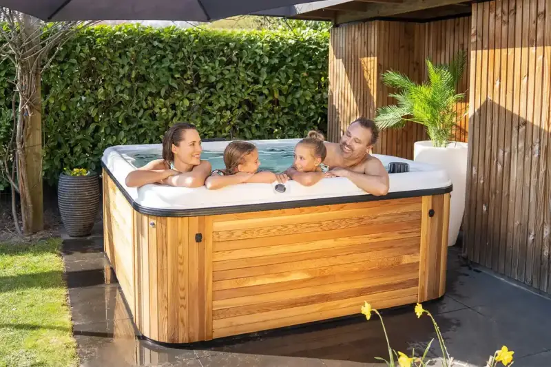 Famille profitant d’un bain nordique Nordic Hottub Spa avec finition en cèdre rouge