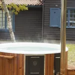 Bain nordique Skargards Rojal chauffé avec poêle intégré dans un jardin privé