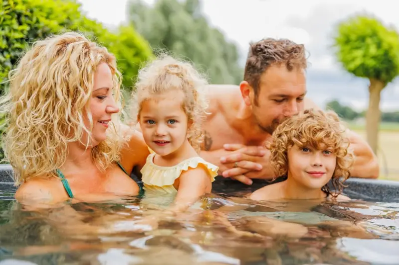 Blij gezin dat samen geniet in een warme hottub
