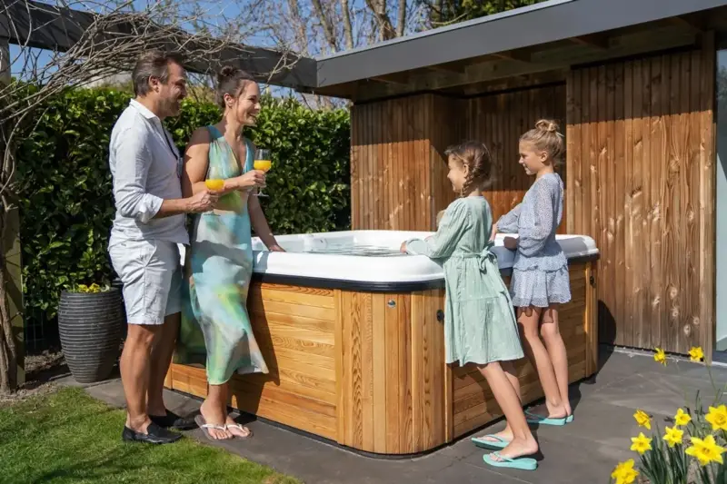 Famille s’essuyant après un bain nordique Nordic Hottub Spa avec finition en cèdre rouge dans le jardin