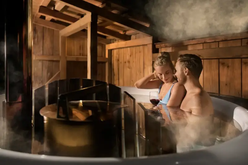 Stel geniet van een wijntje in de stomende Skargards Panel hottub met interne kachel