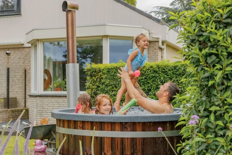 Blij gezin dat samen geniet van een warme hottub in de tuin