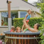 Blij gezin dat samen geniet van een warme hottub in de tuin