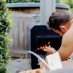 Man die externe houtgestookte hottubkachel opstookt in de tuin